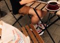 Hombre usando una computadora portátil, sentado en una mesa de un entorno regional chileno tomando café