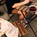 Hombre usando una computadora portátil, sentado en una mesa de un entorno regional chileno tomando café